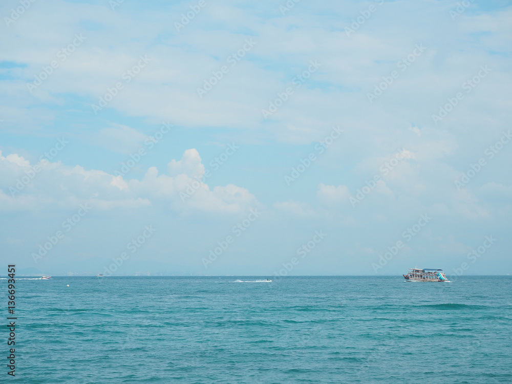 fishing boat in blue sea with clouds sky background in Thailand. Relaxing moments in summer seasons travel. Tropical nature in vacation time.