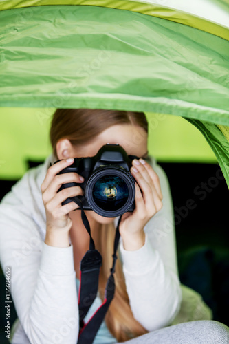 Young woman witho photo camera in a tent on the nature photo