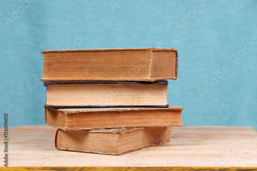 Stack of hardback books on wooden table. Back to school.