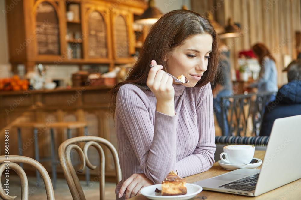 Beautiful brunette using laptop in cafe. Blogger work concept Beautiful brunette using laptop in cafe. Blogger work concept