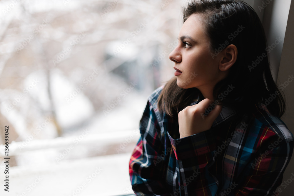 Woman looking out the window lost in thought Woman looking out the window lost in thought