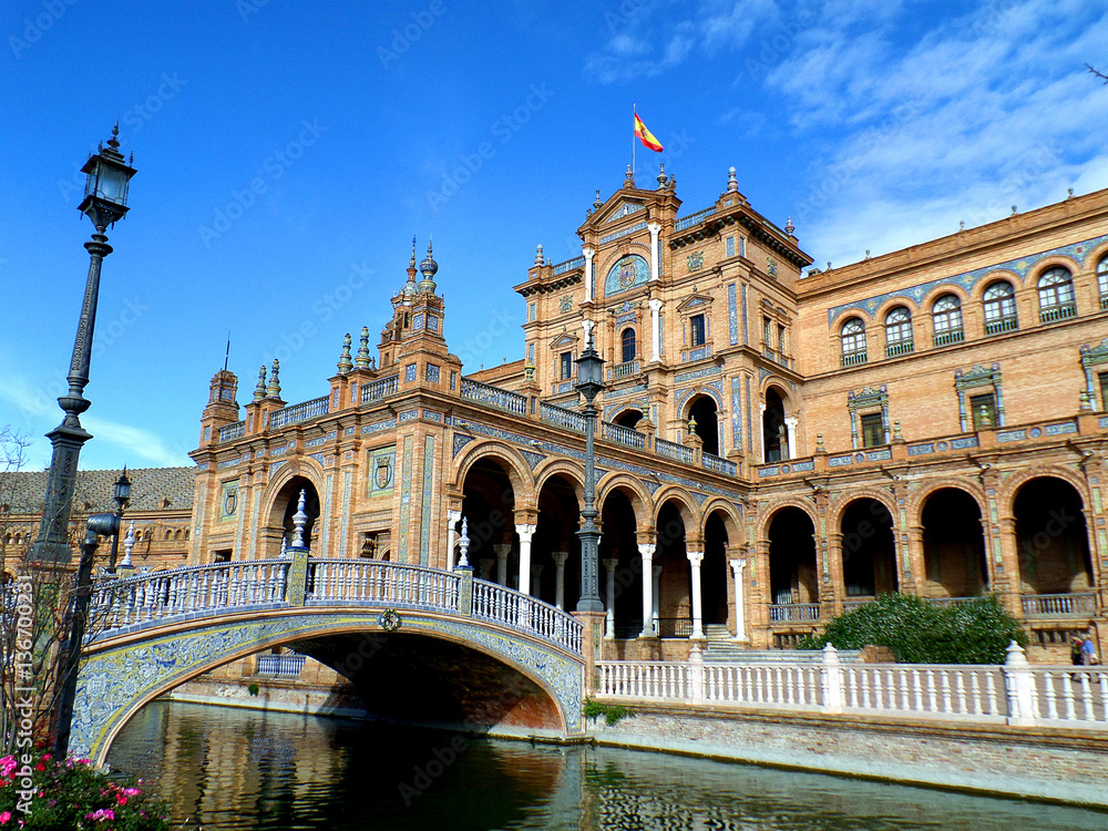 Gorgeous Decorated Tiled Bridge and the Architecture Plaza de Espana against the Vivid Blue Sky, Seville in Spain 