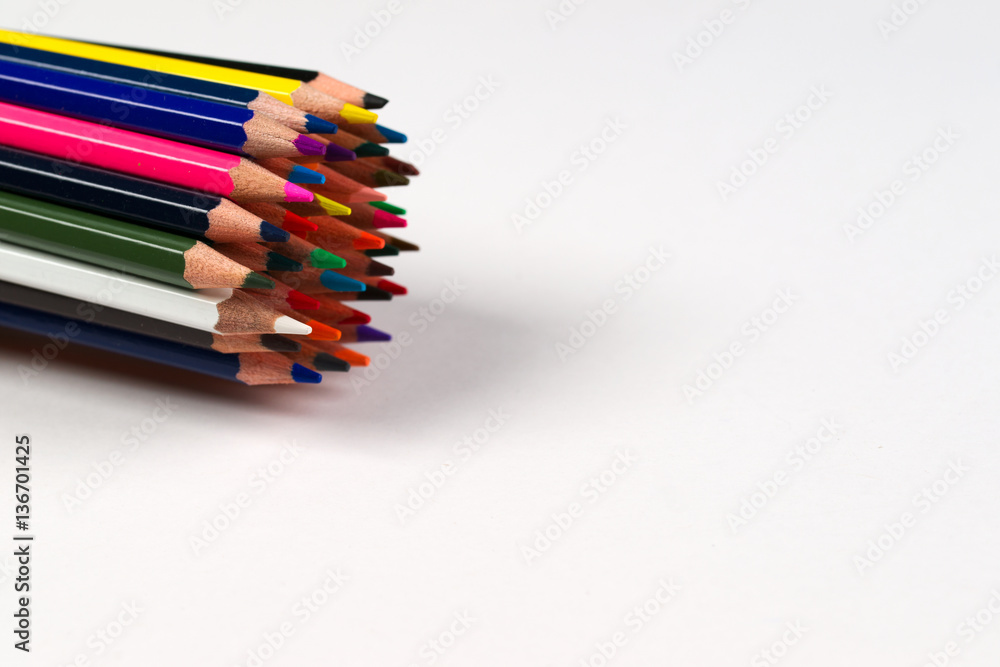 Multicolored pensils and elastic in the box on the paper.