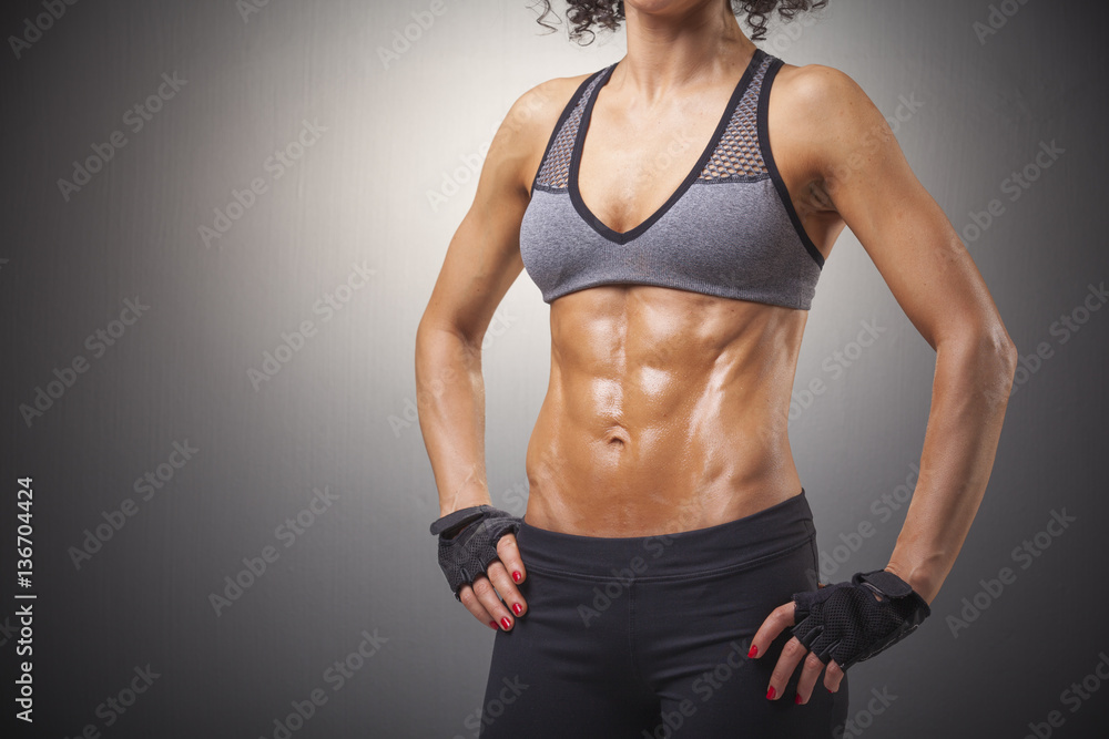 Fitness woman with beautiful body on gray background