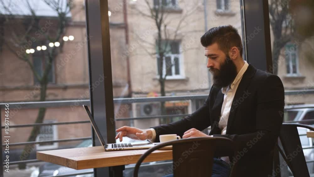 Young happy businessman with laptop in cafe Young happy businessman with laptop in cafe