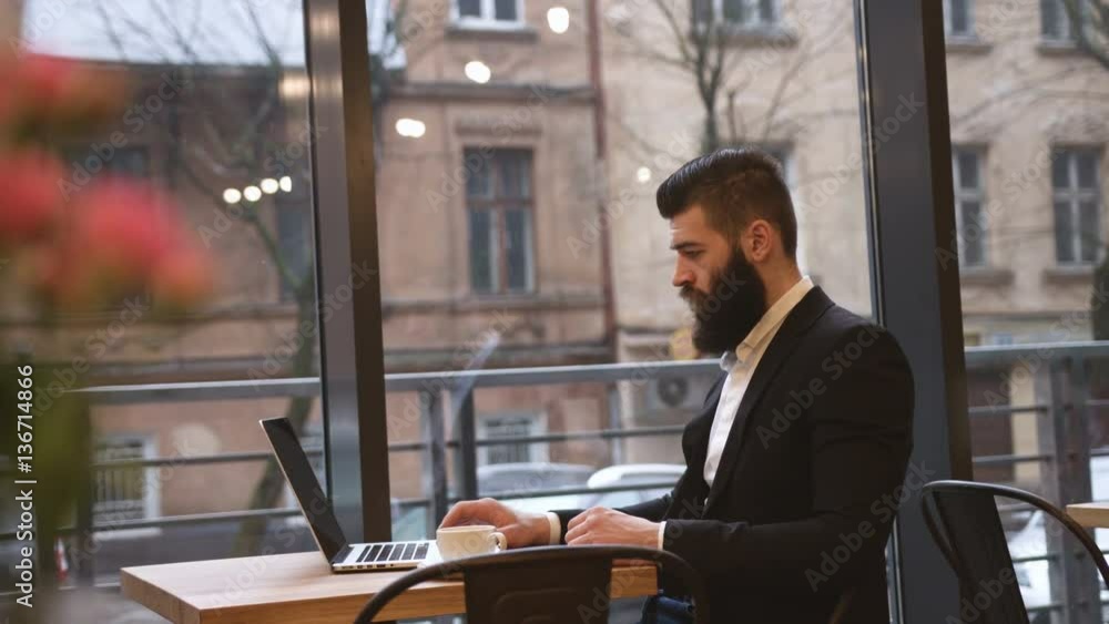 Young happy businessman with laptop in cafe Young happy businessman with laptop in cafe