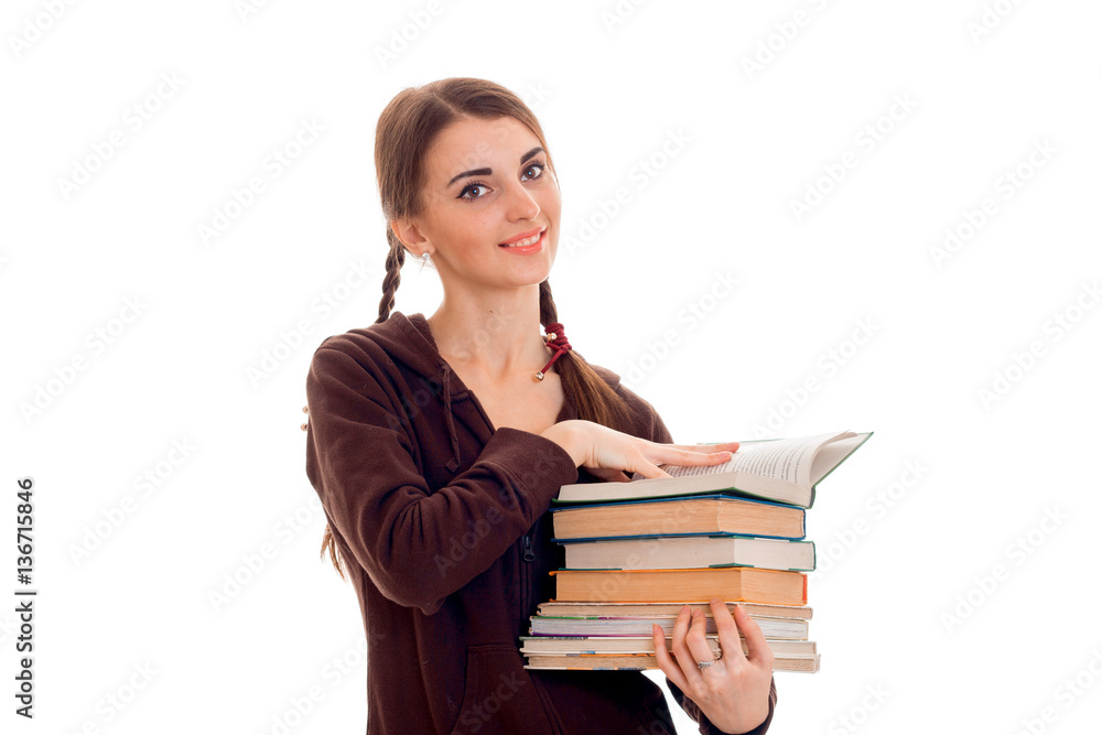 cheerful young student girl with books in brown sport clothes looking at the camera and smiling isolated on white background. student years concept. study concept. cheerful young student girl with books in brown sport clothes looking at the camera and smiling isolated on white background. student years concept. study concept.