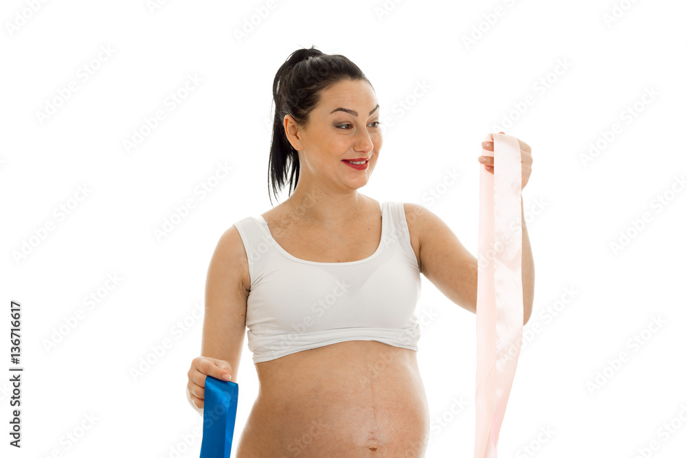 cheerful brunette pregnant woman with big belly chooses a color of tape isolated on white background cheerful brunette pregnant woman with big belly chooses a color of tape isolated on white background