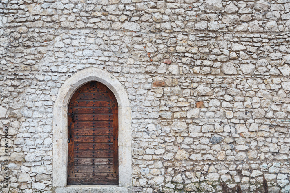 Old wall and the front door in the medieval castle in Krakow Old wall and the front door in the medieval castle in Krakow