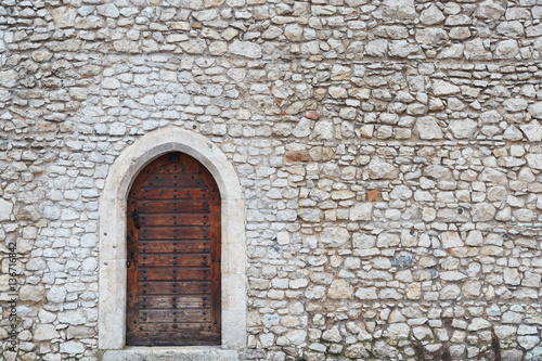 Old wall and the front door in the medieval castle in Krakow