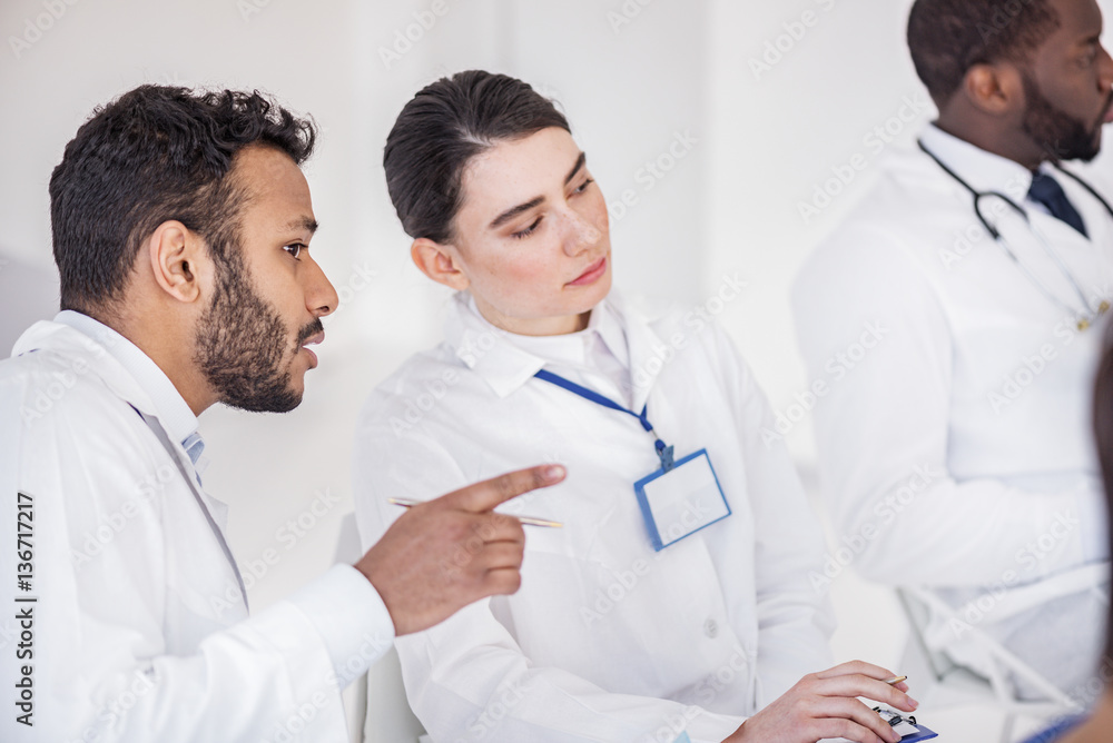 Attentive doctors speaking during meeting in clinic Attentive doctors speaking during meeting in clinic