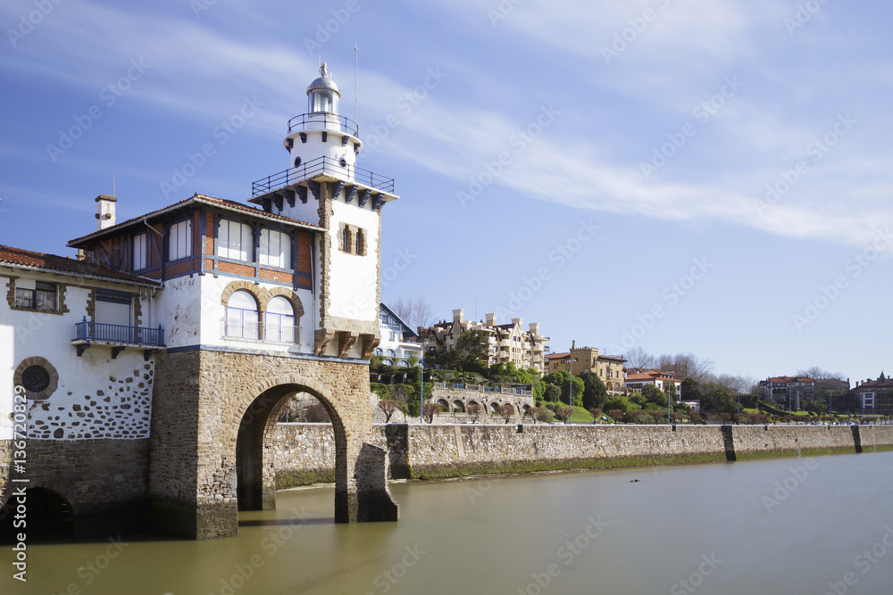 Arriluce lighthouse in the coast of Getxo, Biscay, Spain. Long exposure shot, on a sunny day.