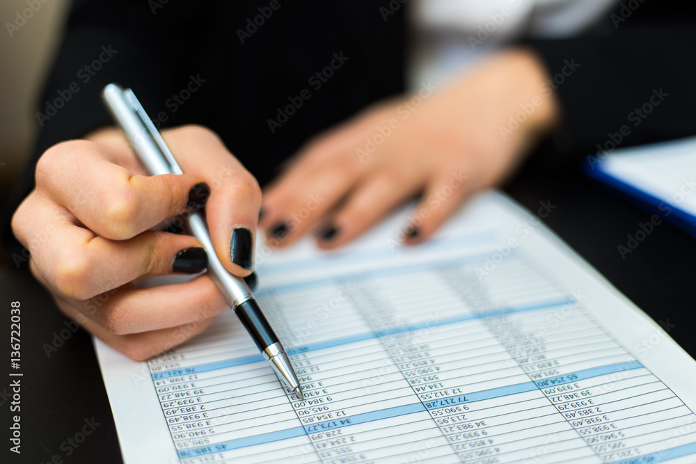 Businesswoman writing on a document Businesswoman writing on a document