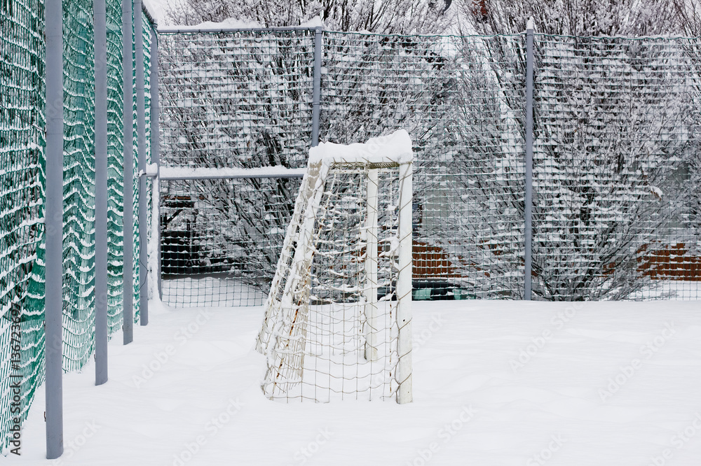 public playground in winter, snowy football field for children public playground in winter, snowy football field for children