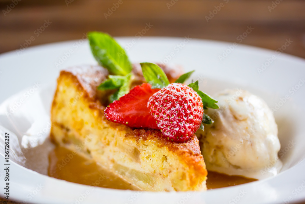 A piece of cheesecake with fresh strawberries, mint and a scoop A piece of cheesecake with fresh strawberries, mint and a scoop