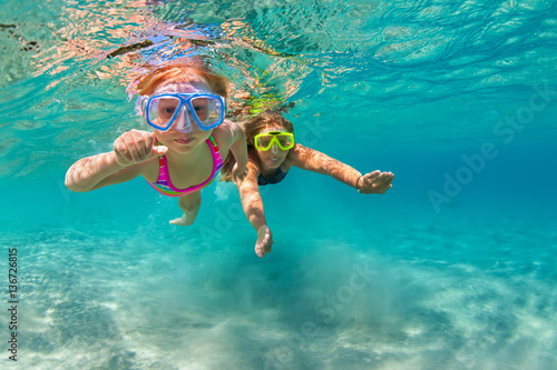 Happy family - mother with baby girl dive underwater with fun in sea pool. Healthy lifestyle, active parent, people water sport outdoor adventure, swimming lessons on beach summer holidays with child © Tropical studio