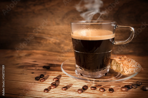 Cup of coffee and beans on dark wooden background