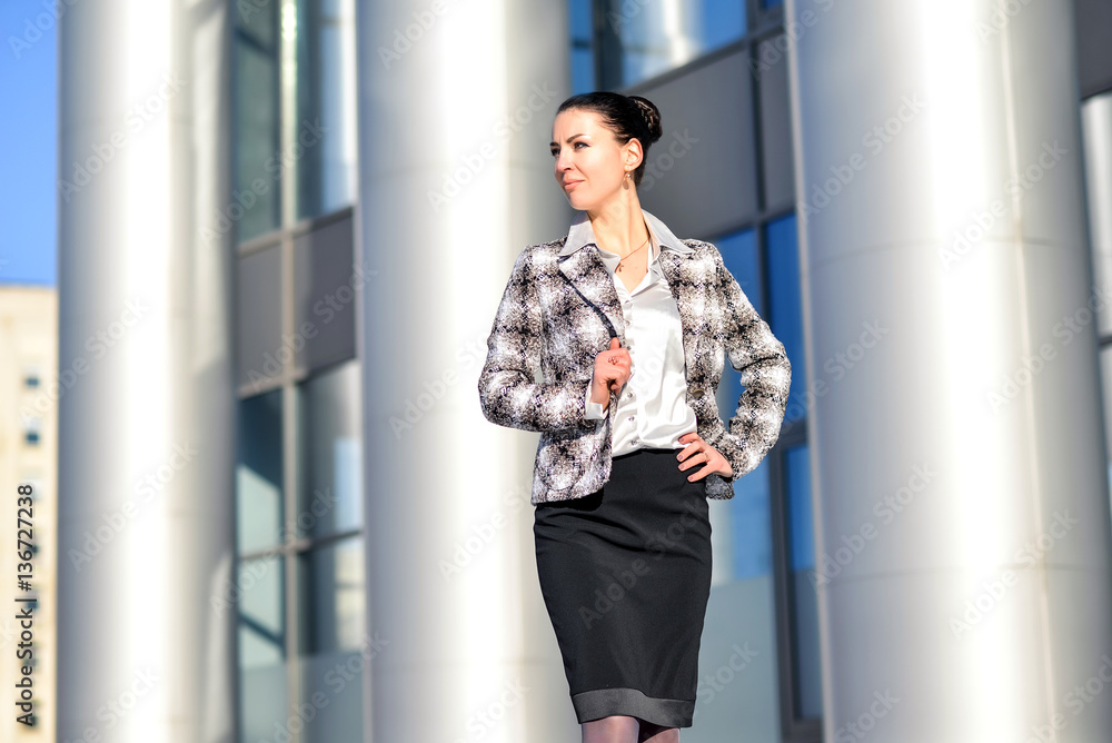 Young successful businessman standing on the street between the Office of columns on a background of office space. Businessman wearing a suit jacket and white shirt.