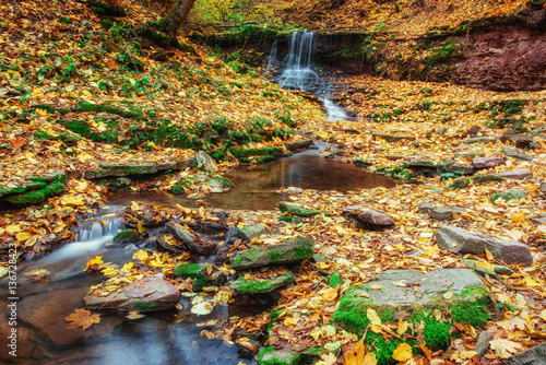 beautiful waterfall in forest, autumn landscape.