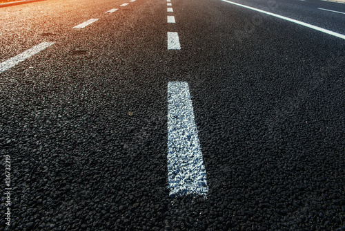 New asphalt texture with white dashed line. photo