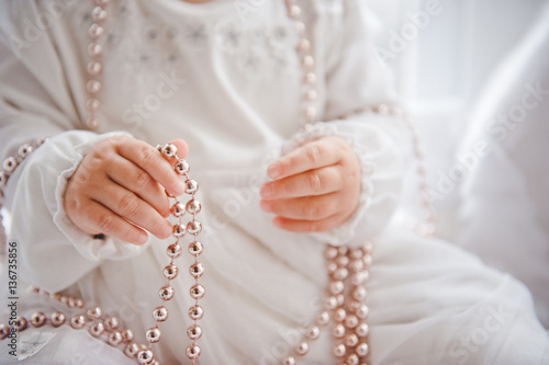 little baby girl in white dress with beads