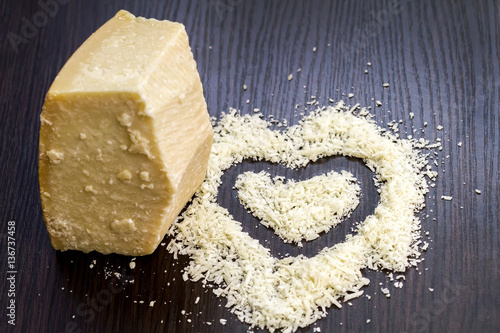 Pieces of parmigiano reggiano or parmesan cheese on black wood b