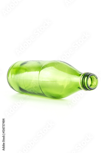 Glass green bottle lying down isolated on white background