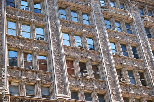 Terra cotta facade in french renaissance style with elaborate decorations around windows and balconies of a building in New York City