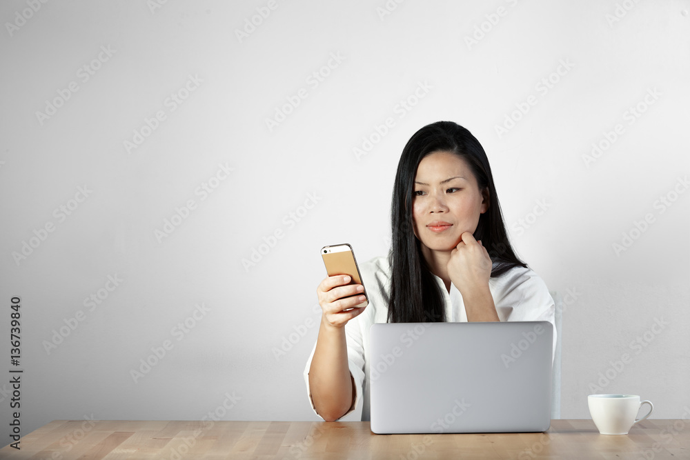 Japanese, asian woman using laptop, mobile while taking a cup of coffee Japanese, asian woman using laptop, mobile while taking a cup of coffee