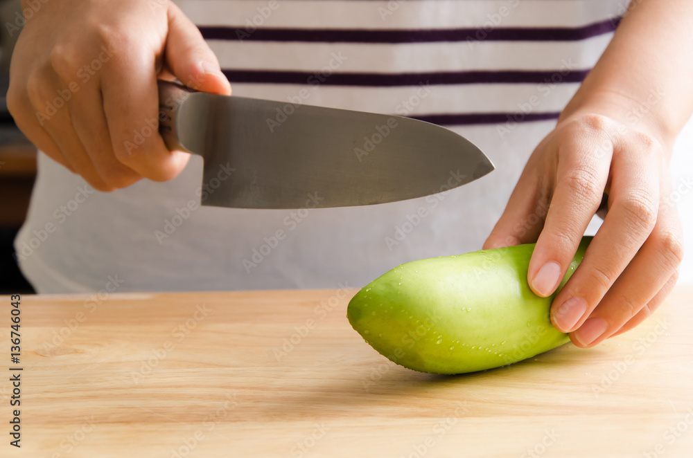 Woman chopping green eggplant on wooden board prepare for cooking Woman chopping green eggplant on wooden board prepare for cooking