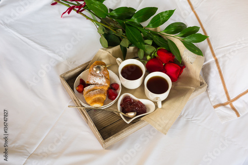 Valentines day table setting with plate, gift, red ribbon and roses. background photo