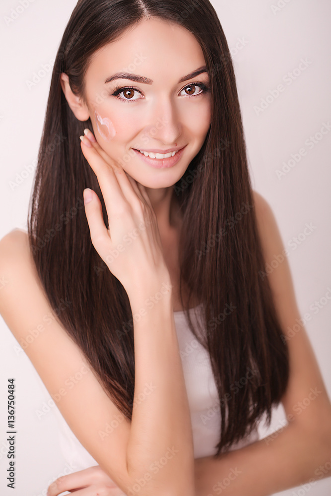 beauty, people, skincare and cosmetics concept - happy young woman with moisturizing cream on hand and facial beauty, people, skincare and cosmetics concept - happy young woman with moisturizing cream on hand and facial