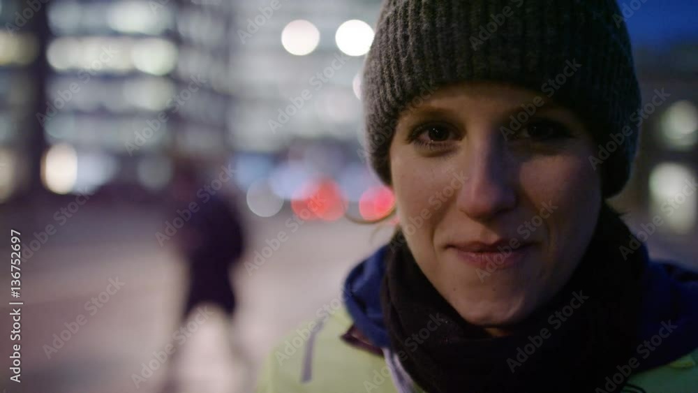 4K Portrait of cheerful young woman smiling to camera in the city at night 4K Portrait of cheerful young woman smiling to camera in the city at night