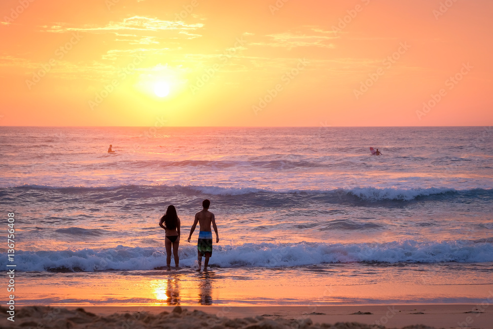 Couple at the beach at sunrise Couple at the beach at sunrise