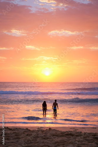 Couple at the beach at sunrise