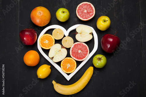 Fruits and heart on black background