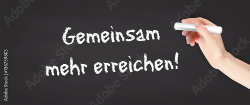 Hand schreibt auf Kreidetafel - Gemeinsam mehr erreichen