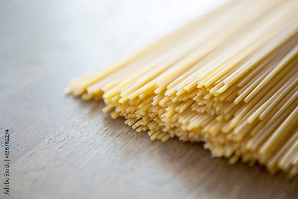Uncooked Italian row of spaghetti on wooden table, Selective foc