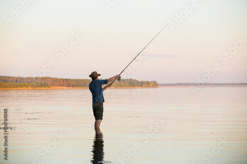 Fisherman with spinning at sunset