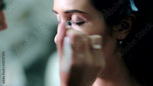 Make-up artist doing the make-up for beautiful girl photo