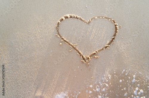 Heart drawn on a sand of beach
