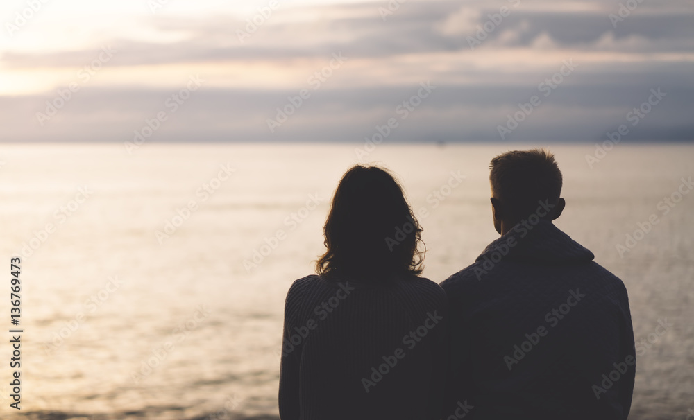 Couple hugging on the beach on background ocean sunrise, silhouette two romantic people cuddling and looking on rear view evening seascape, hipster enjoy  sunset together, travel holidays vacation