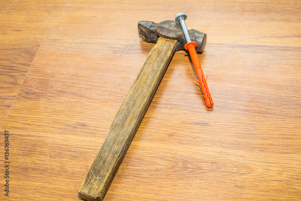 plastic dowel and hammer on wooden background plastic dowel and hammer on wooden background