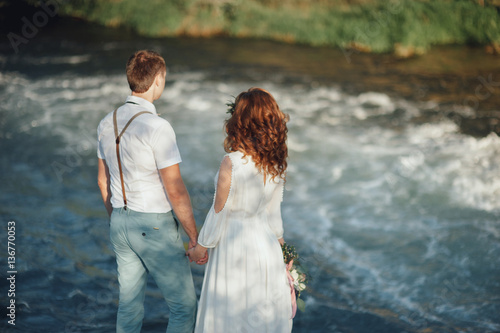 the bride and groom on the background of a mountain stream