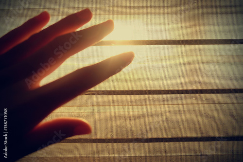 finger and shadow on the  window louver at the sunset