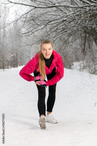 Young woman doing stretching exercises in winter