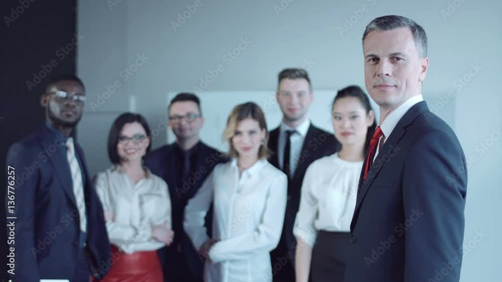 Joyful adult man looking back to colleagues and looking at camera. Joyful adult man looking back to colleagues and looking at camera.