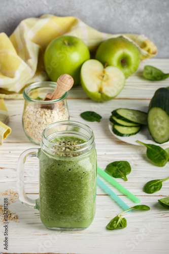 Fresh green smoothie from fruit and vegetables for a healthy lifestyle and ingredients for making dietary drink (spinach, green Apple, cucumber, oatmeal) 