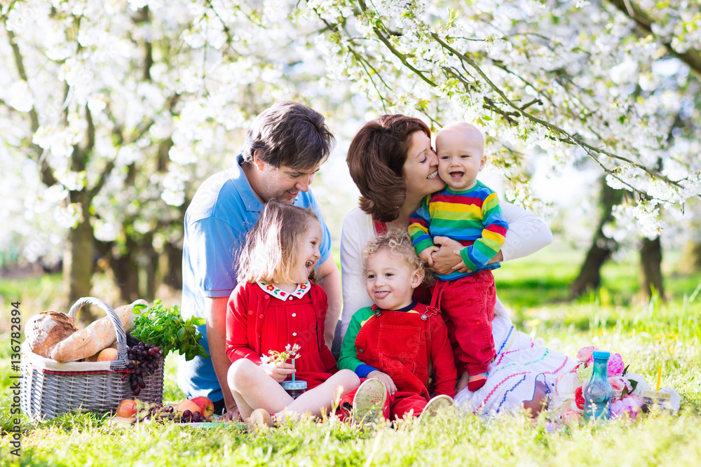 Fototapeta premium Family with kids on picnic in spring garden