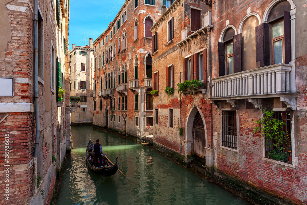 Gondola among old houses in Venice.